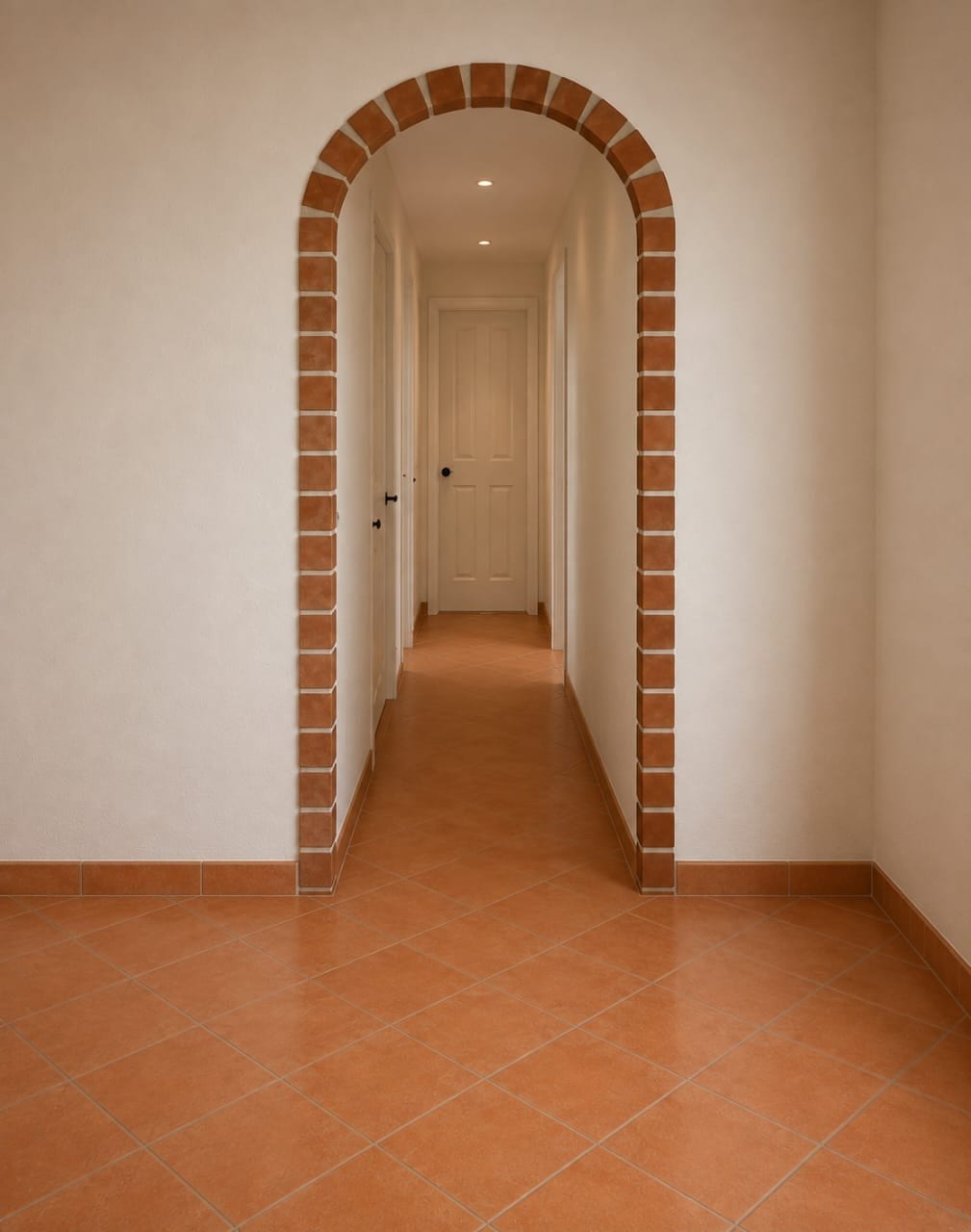 Interior corridor of a Sunrise Villa with terracotta tile flooring and a tiled archway